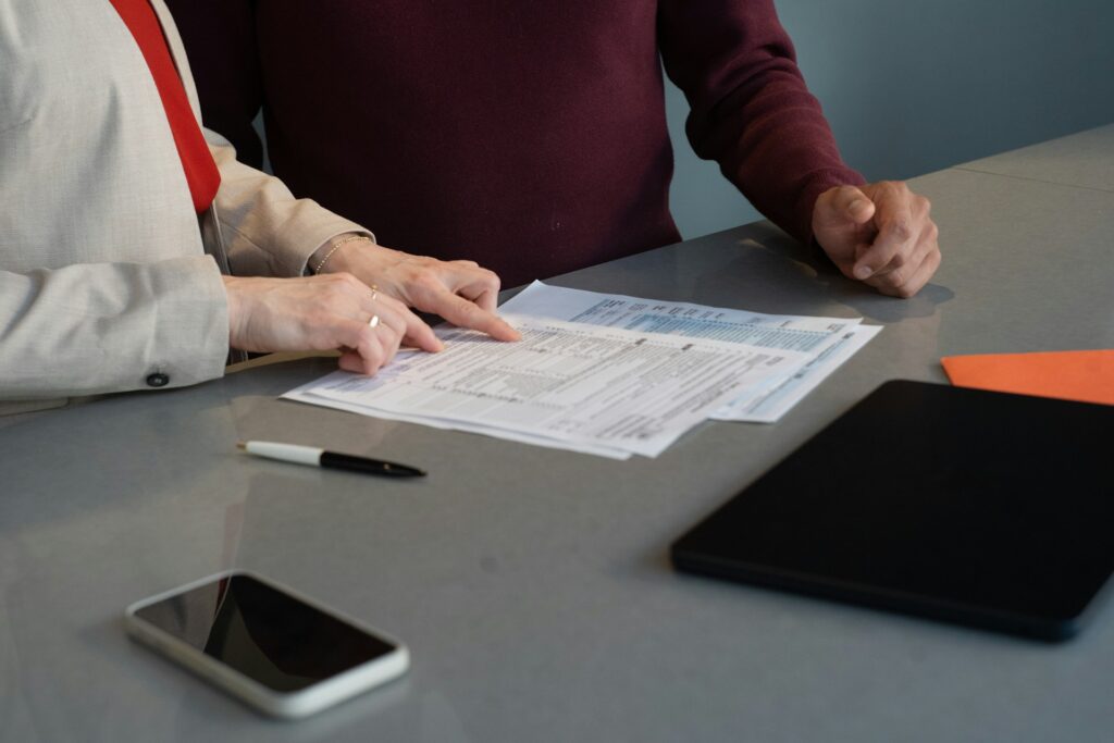 Two people reviewing contract documents at a desk